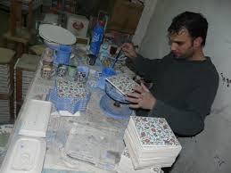Craftsman painting ceramic tiles.