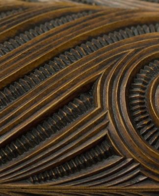 Example of whakairo surface design with haehae/carved parallel ridges and pakati/notching. This is a detail of a waka huia/treasure box carved by Te Rangikapiki Fraser.