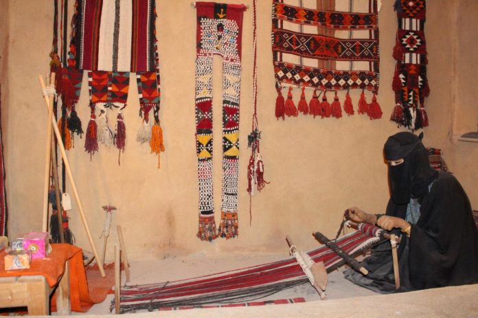 Al-Sadu weaver weaving on a typical floor loom.